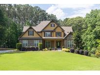 Charming two-story home with stone and siding exterior and manicured front lawn at 3865 Pointer Rd, Loganville, GA 30052