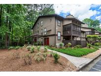 Charming home featuring lush landscaping, mature trees, and a well-maintained lawn at 504 River Run Dr, Atlanta, GA 30350
