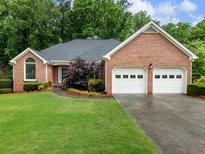 Charming brick home with an attached two car garage and a well manicured front lawn at 2910 Waverly Place Dr, Dacula, GA 30019