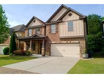 Inviting two-story home with a well-manicured lawn, stone accents, and a convenient two-car garage at 3943 Ridge Grove Way, Suwanee, GA 30024