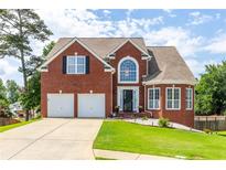 Inviting two-story brick home with a well-manicured lawn, a two-car garage, and a classic design at 535 Sugar Gate Ct, Lawrenceville, GA 30044
