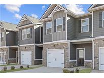 Charming townhome featuring a gray siding, brick accents, and a convenient one-car garage at 225 Ivey Ter, Temple, GA 30179