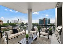 Inviting balcony features a seating area and an outdoor grill with stunning city views at 3107 Peachtree Ne Rd # 1005, Atlanta, GA 30305