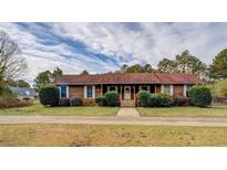 Charming single story home featuring a well-maintained lawn, mature trees, and a classic facade at 5687 Highway 212, Covington, GA 30016