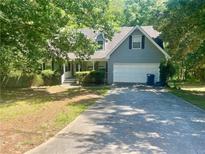Charming home with two-car garage and partially shaded front yard in a peaceful, wooded setting at 1075 Crystal Water Dr, Lawrenceville, GA 30045