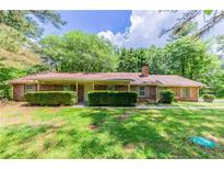 Charming brick ranch-style home with mature trees and well-manicured landscaping at 1296 Carman Se Ct, Conyers, GA 30013