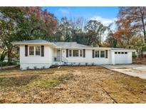 Charming renovated ranch-style home with white siding, a well-maintained lawn, and a single car attached garage at 2376 Cross Nw St, Atlanta, GA 30318
