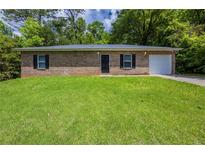 Charming single-story brick home with lush green lawn and attached single car garage at 1808 Arkose Se Dr, Atlanta, GA 30316