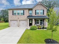 Charming two-story brick home featuring a manicured lawn and a welcoming front porch at 201 Kingfisher Walk, Covington, GA 30014