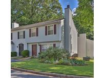 Charming townhome with manicured lawn, blooming garden, and a classic light gray facade with brown shutters at 6359 Wedgeview Dr, Tucker, GA 30084
