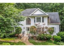 Charming two-story home with a brick facade, arched window, and lush landscaping at 1763 Benningfield Sw Dr, Marietta, GA 30064