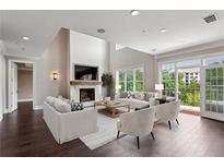 Bright living room boasts a fireplace, balcony access, hardwood floors, and neutral decor at 3280 Stillhouse Se Ln # 401, Atlanta, GA 30339