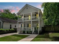 Charming two-story home featuring a double porch, freshly painted exterior, and manicured lawn at 1039 Fern Se Ave, Atlanta, GA 30315
