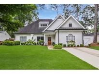 Charming home boasts a well-manicured lawn, beautiful landscaping, and a welcoming wood front door at 114 Karland Nw Dr, Atlanta, GA 30305