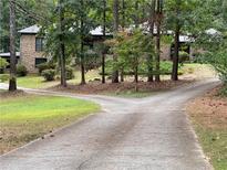 Brick home with mature trees, and a long driveway to the front of the home at 1935 Lamp Post Ln, Lawrenceville, GA 30043