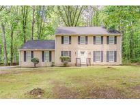 Two story traditional home with light siding and black shutters surrounded by mature trees at 205 N Fayette Dr, Fayetteville, GA 30214