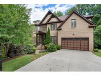 Beautiful brick home showcasing a well-manicured lawn, mature trees, and an attached two-car garage at 3301 Chastain Ridge Dr, Marietta, GA 30066