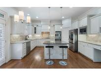 Spacious white kitchen features granite countertops, stainless steel appliances, and a large island at 3301 Chastain Ridge Dr, Marietta, GA 30066