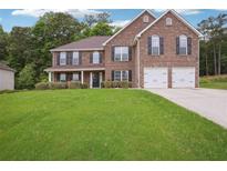Charming two-story brick home with a well-manicured lawn and attached two-car garage at 4549 Clarks Creek Ter, Ellenwood, GA 30294
