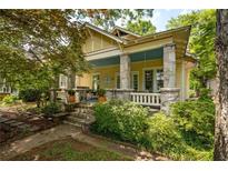 Charming home featuring a welcoming front porch, stone columns, and beautiful landscaping at 1290 Mclendon Ne Ave, Atlanta, GA 30307