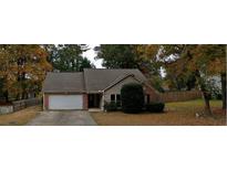 Charming single-Gathering home featuring a brick facade and attached garage, nestled among mature trees and a well-manicured lawn at 4262 Apache Se Dr, Acworth, GA 30102