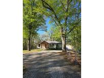 Charming single-story home with a gable roof, and lots of trees in a peaceful wooded setting at 1016 Green Dr, Canton, GA 30114