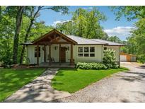 Charming home with inviting front porch, stone path, mature trees, and lush lawn at 1016 Green Dr, Canton, GA 30114