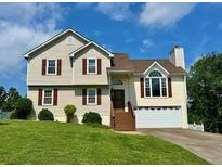 Two-story home with vinyl siding, brown shutters, and a well-manicured front lawn on a sunny day at 19 Magnolia Ne Ct, Rydal, GA 30171