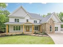 Stunning two-story home featuring a stone facade and inviting covered front porch at 2555 Chattahoochee Ln, Cumming, GA 30041