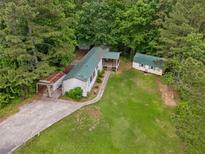 Secluded home with multiple structures, mature trees and a spacious lawn, perfect for serene country living at 4934 Pickys Se Holw, Acworth, GA 30102