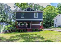 Charming two-story home featuring a cozy front porch and a well-manicured lawn at 233 Clayton St, Fairburn, GA 30213