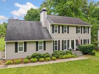 Charming two-story home featuring gray siding, black shutters, landscaped yard, and a classic chimney at 2166 Carlyle Dr, Marietta, GA 30062
