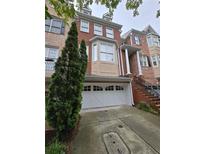 Charming brick townhome featuring a two-car garage and a beautifully landscaped front yard at 1042 Emory Parc Pl, Decatur, GA 30033