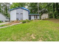 View of the home with a grassy front yard, front entry, and partial roof repair at 2347 Fairway Sw Cir, Atlanta, GA 30331