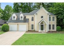 Charming two-story home with a two-car garage, well-manicured lawn, and mature trees at 6895 Old Fox Trl, Stone Mountain, GA 30087
