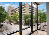 Stunning city view from the condo's large window, showing Peachtree Street and surrounding buildings on a bright, sunny day at 867 Peachtree Ne St # 202, Atlanta, GA 30308