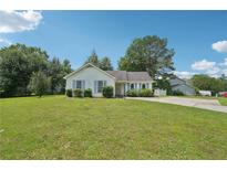 Charming single-story home with a lush green lawn and light blue shutters on a sunny day at 742 Redland Dr, Jonesboro, GA 30238
