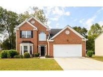 Charming two-story brick home with a well-manicured lawn and attached two-car garage at 2715 Haynes Club Circle, Grayson, GA 30017