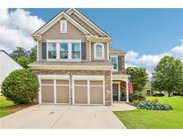 Charming two-story home with a stone and shingle facade, an attached two-car garage and a well-manicured lawn at 5225 Stonehaven Vw, Cumming, GA 30040