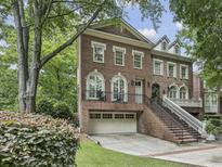 Elegant brick home featuring a well-manicured lawn, attached garage, and welcoming front porch at 604 Timm Valley Ne Rd # A, Atlanta, GA 30305