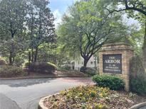 Community sign with manicured landscaping, surrounded by mature trees and seasonal flowers at 24 Dunwoody Springs Dr, Atlanta, GA 30328