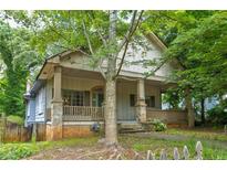 Charming craftsman-style home with a covered porch, stone accents, and mature trees providing shade at , Atlanta, GA 30310
