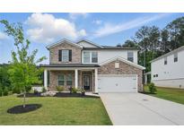 Charming two-story home with brick and siding, well-manicured lawn, and a two car garage at 4477 Bethany Manor Dr, Snellville, GA 30039