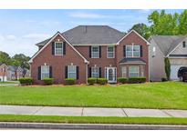 Beautiful two-story brick home with a well-manicured lawn and dark shutters at 6330 Shell Sw Dr, Atlanta, GA 30331