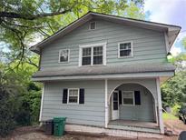 Two-story home with light blue siding, black shutters and a covered front porch entryway at 1142 Pluma Se Dr, Atlanta, GA 30316