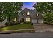 Charming two-story brick home with a well-manicured lawn and a two-car garage at 1255 Hidden Creek Pt, Cumming, GA 30040