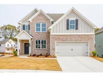 Charming two-story home featuring a brick and gray facade, a two-car garage, and a well-manicured lawn at 1730 Fulmont Cir, Mableton, GA 30126