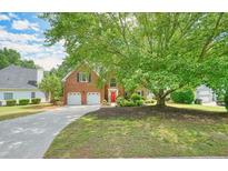 Charming two-story brick home with a well-manicured lawn and mature trees offering great curb appeal at 510 Morning Mist Ct, Alpharetta, GA 30022