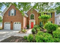 Charming two-story brick home featuring a well-manicured lawn, red door, and attached two-car garage at 510 Morning Mist Ct, Alpharetta, GA 30022