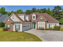 Charming two-story home with a well-manicured lawn, attached garage, green door and lush landscaping at 127 Autumn Run Pl, Villa Rica, GA 30180